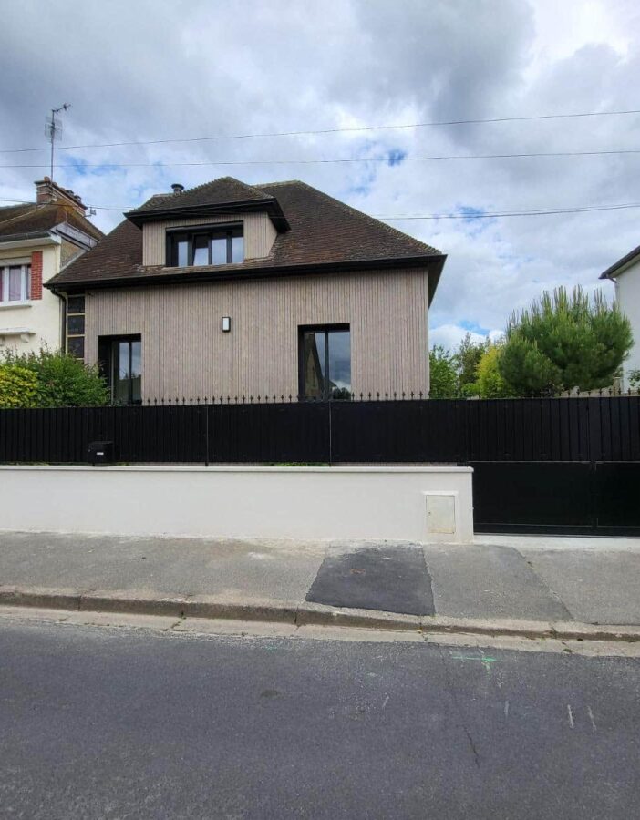 clôture et portail noirs devant une maison