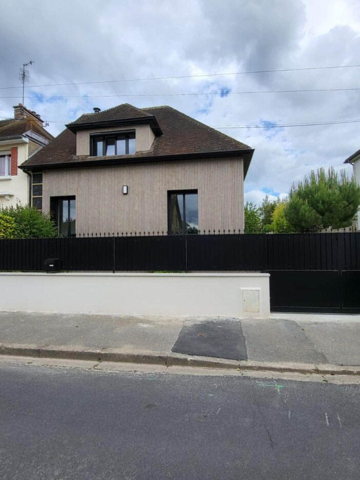 clôture et portail noirs devant une maison